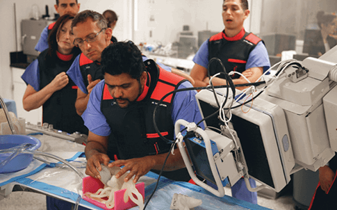 El Dr. Iyer evalúa una réplica del corazón de un paciente durante una simulación quirúrgica antes de tratar al paciente.