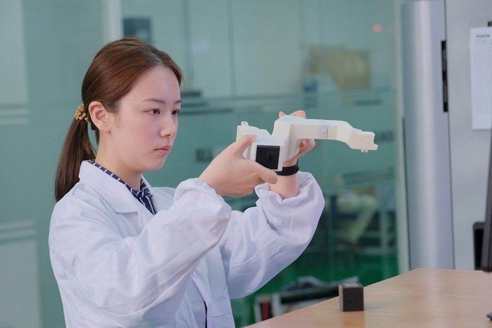 Kohler application engineer Chen Lin examines a 3D printed part.