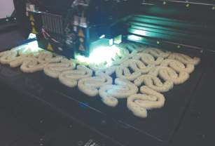 A myriad of dental implants are displayed on a build tray. 