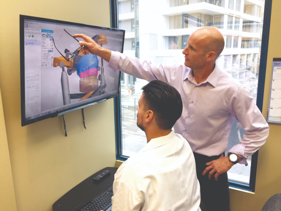 Jeff Player and Manuel Stanescu review the digital design of a splint.