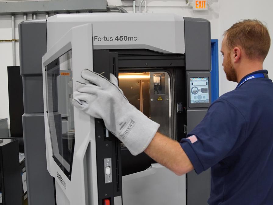 Worker closing Fortus 450mc 3D printer