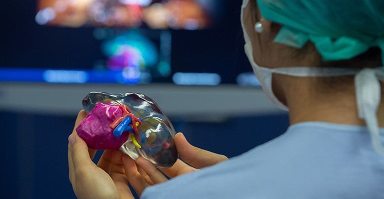 a doctor holding 3d printed heart model