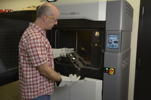 Rob Humphries removing an FDM Nylon 12CF part from Thule’s 3D printer.