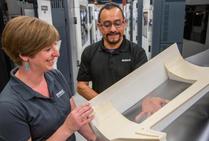 Woman and Man holding very large 3d printed part at Stratasys Direct