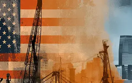 flag in background factory and industrial buildings in foreground to depict America Dynamism