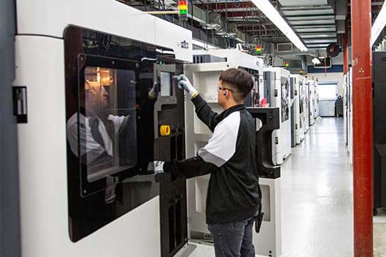 Worker starting 3d printing job on large format industrial 3d printer | Stratasys Direct