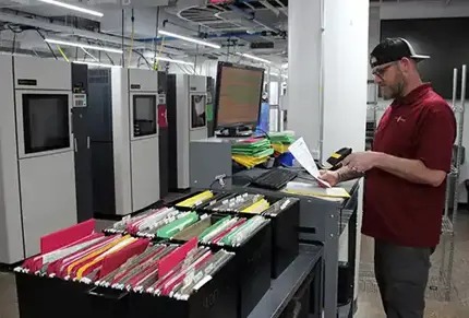 Man scaning documents showing the high traceability standards at Stratasys Direct