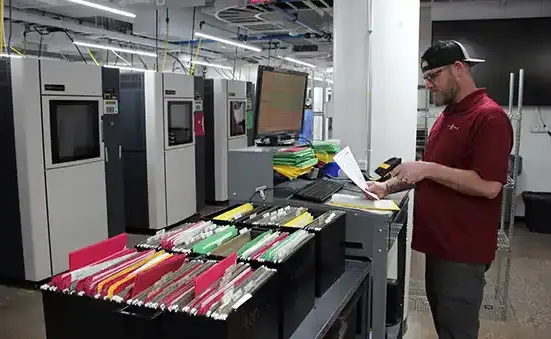 Man scaning documents showing the high traceability standards at Stratasys Direct