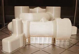 FDM 3D printed part on build plate headed to finishing.