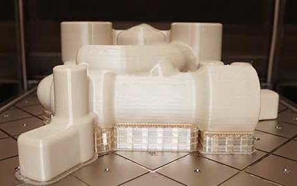 FDM 3D printed part on build plate headed to finishing.