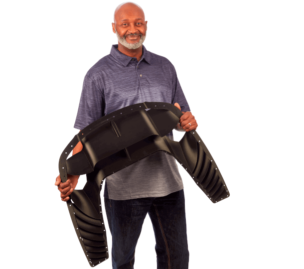 Man holding fused deposition modeling 3d printed black hood vent | Stratasys Direct