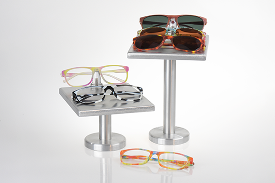 Display of colorful PolyJet 3D-printed eyeglass and sunglass frames on metal stands for retail or prototype showcasing.